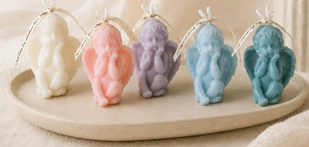 A row of cherub-form candles in pastel colors on a stone tray