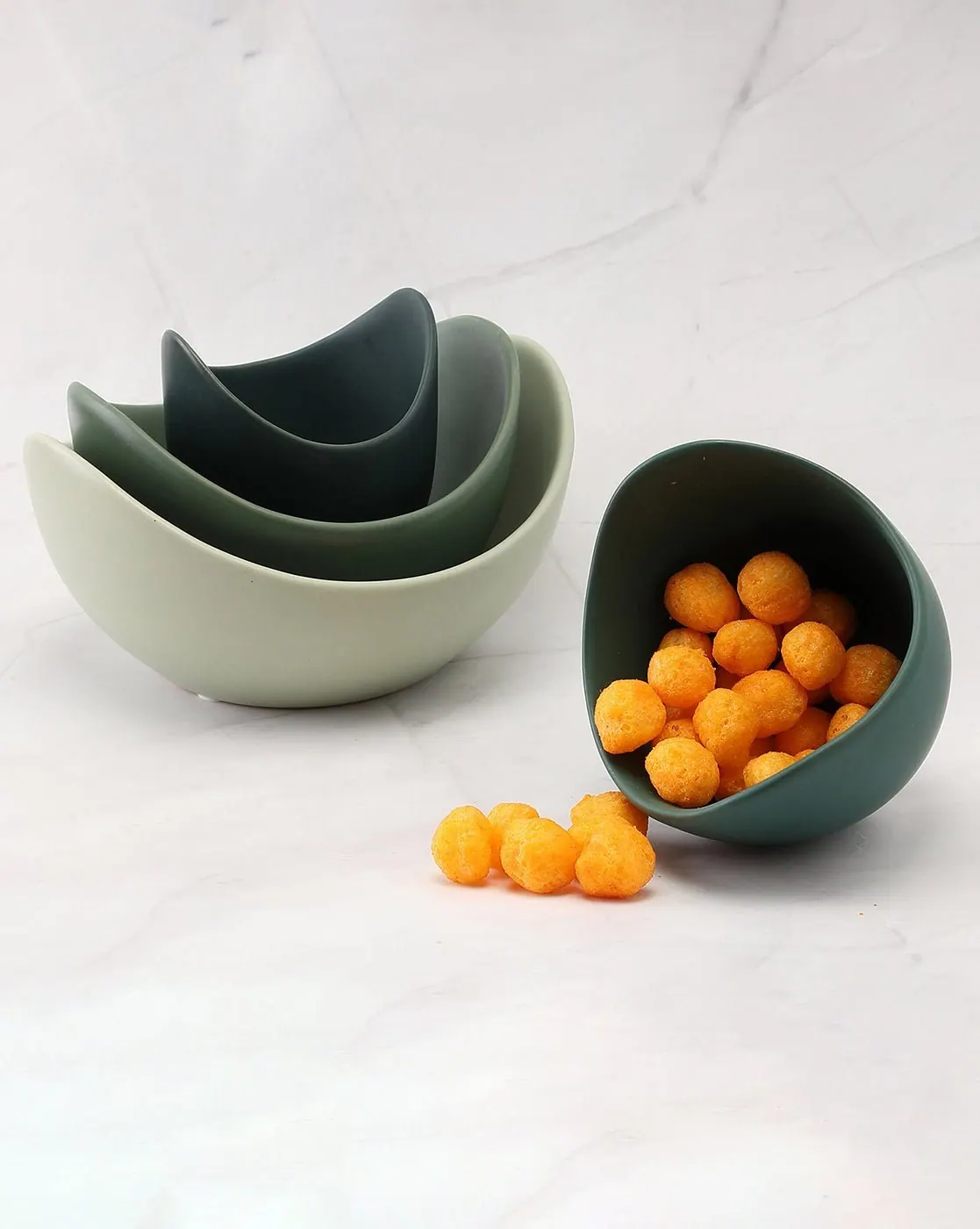 Nesting ceramic serveware bowls in sage and forest green with kumquats