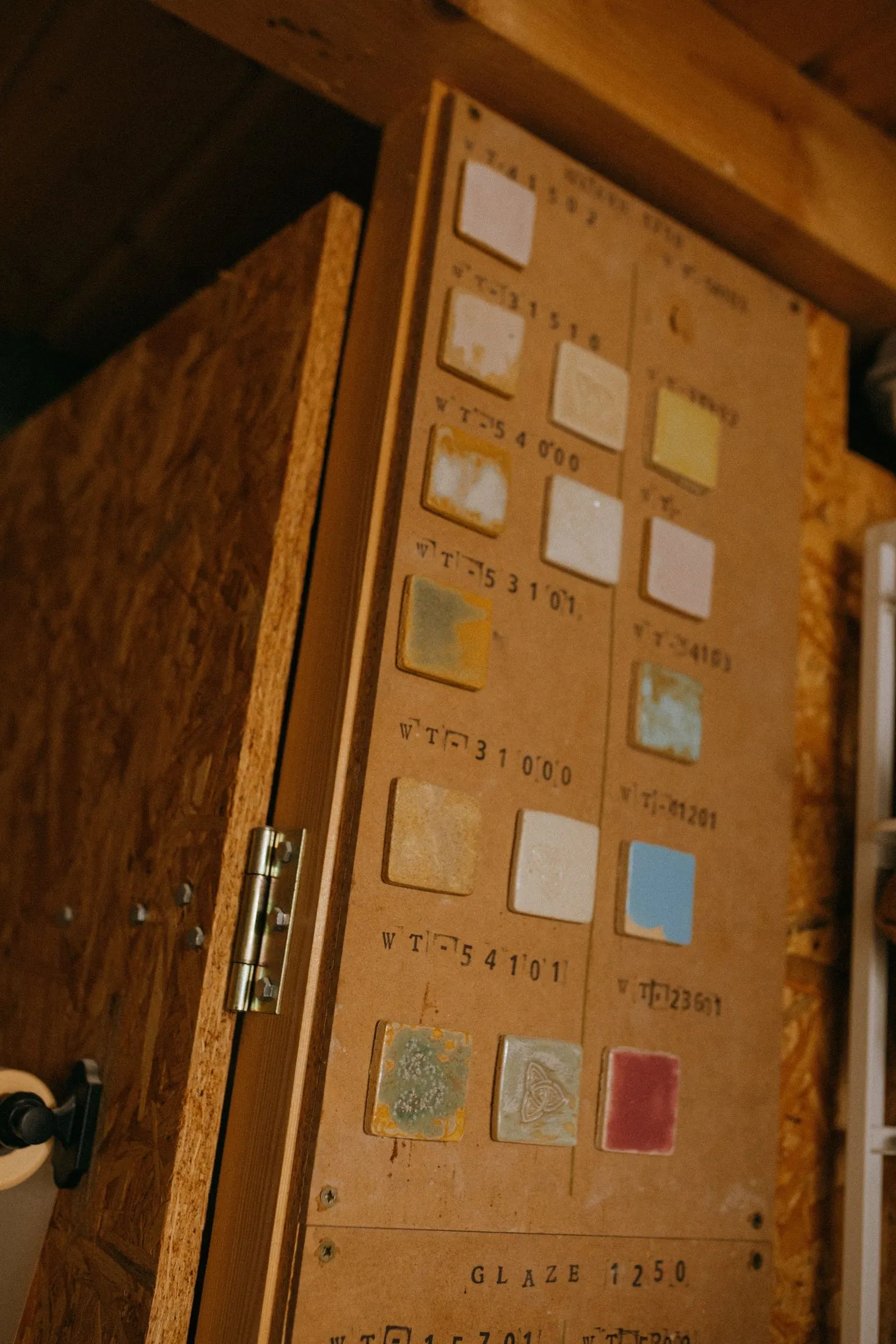 A board of ceramic glaze test tiles in a workshop
