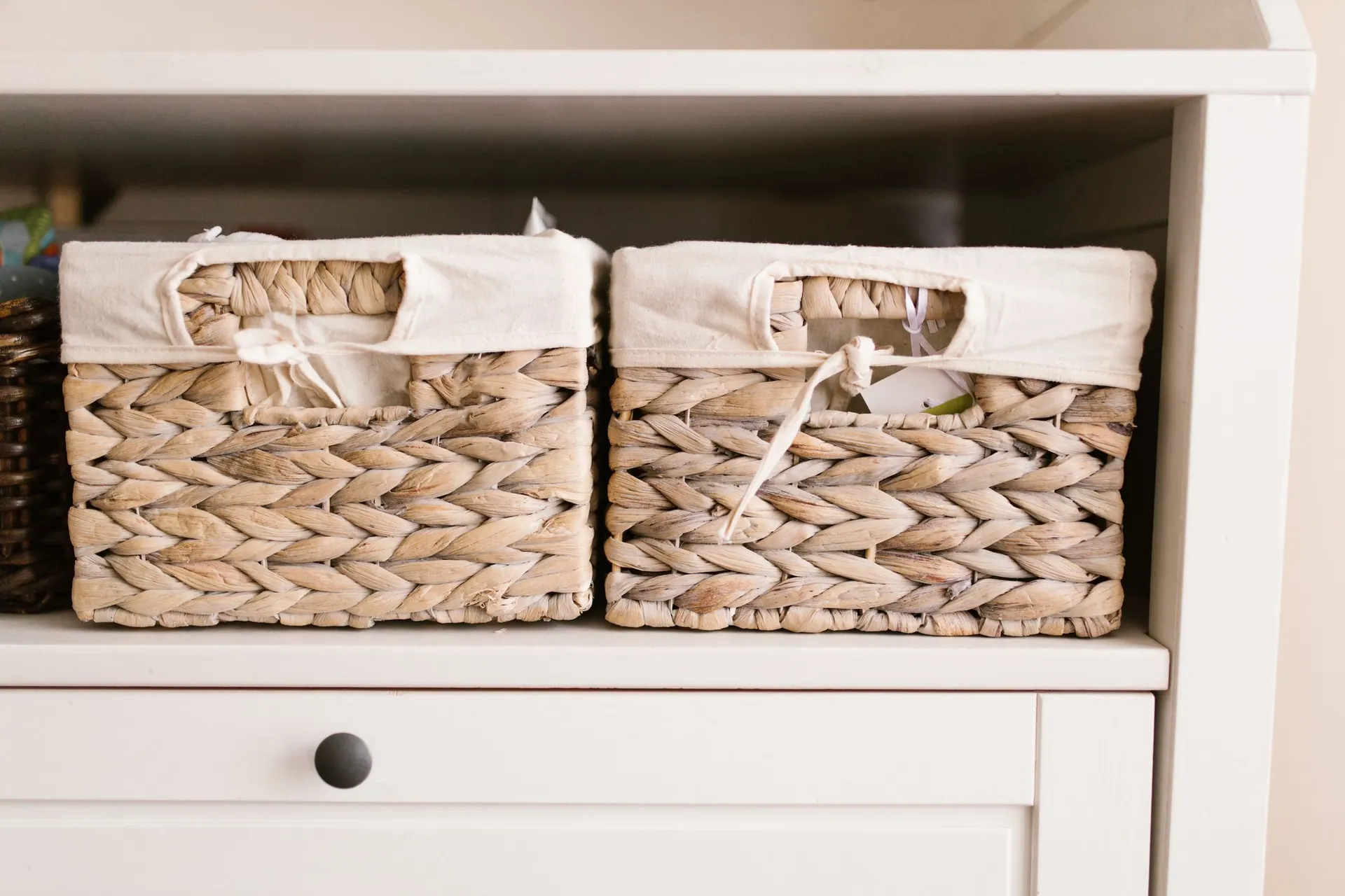 Linen-lined seagrass baskets on white shelving
